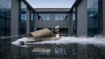 A modern building with a reflective water feature in front.