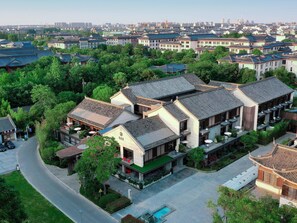 A traditional Chinese courtyard with modern buildings, surrounded by greenery. - Blossom Hill Hotel Yangzhou Slender West Lake (Yangzhou)