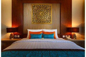 Relax in comfort with a large bed, wooden nightstands, and a decorative wall panel.
