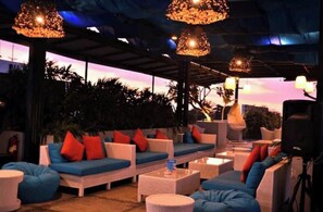 Relax in this serene outdoor seating area surrounded by lush greenery and offering a view of the sky.