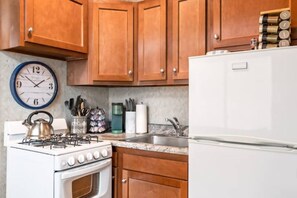 Enjoy cooking in this well-equipped kitchen with a gas stove, kettle, coffee maker, and refrigerator.
