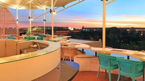 An outdoor bar area with seating and a view of the city skyline at dusk. - Double-Bedroom With Terrace In Seminyak (Bali)