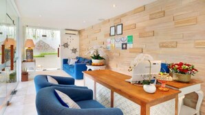 Una sala de estar moderna con una pared de madera, un sofá azul, una mesa de centro de madera y objetos decorativos.