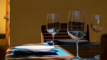 Een eettafel met twee wijnglazen, een wit bord en een blauwe servet.
