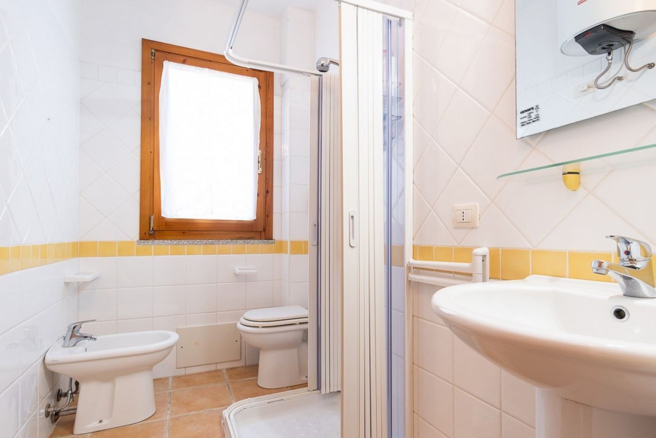 Een badkamer met douche, toilet, bidet en wastafel.