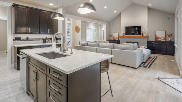 A modern kitchen with a central island, dark cabinets, and pendant lighting. - Family Friendly w/ Suncadia Pool Access (Cle Elum)