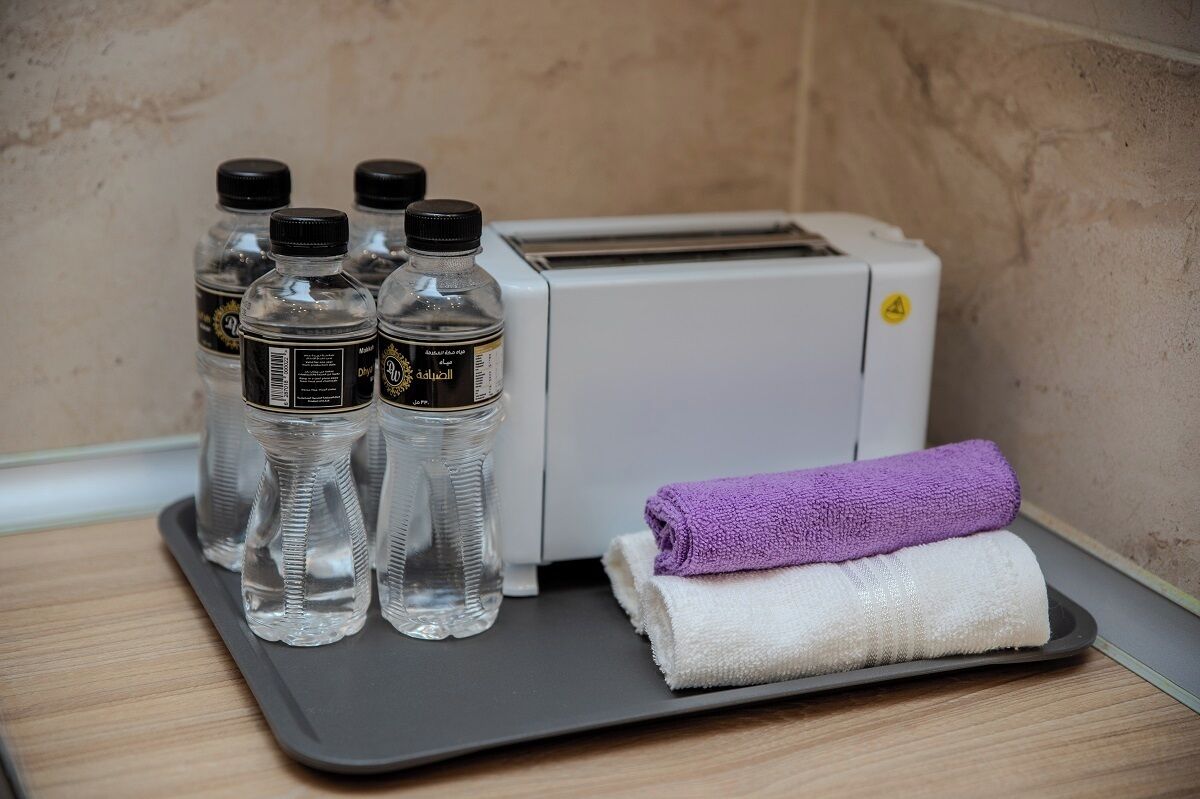 Un plateau contenant des bouteilles d’eau et des serviettes, posé sur une table à côté d’un grille-pain.