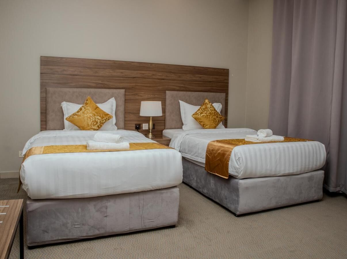 Une chambre d’hôtel avec deux lits, chacun doté d’une tête de lit, d’oreillers et d’une lampe de chevet.