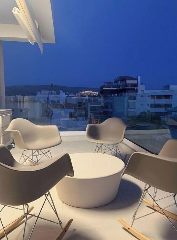 Enjoy a serene city view from this stylish balcony with a round table and four chairs.