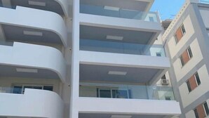 A multi-story building with balconies and large windows.