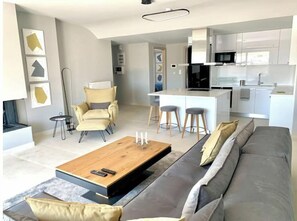 Relax in this stylish living space with a sofa, dining table, and modern kitchen.