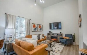 Relax in this stylish living room with a comfortable sofa, flat-screen TV, and cozy fireplace.