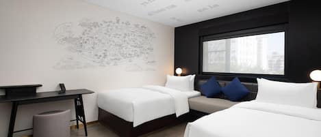 A hotel room with two beds, a desk, a chair, a trash bin, and a large window.