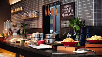 Una mesa de buffet con diversos alimentos y utensilios de cocina.