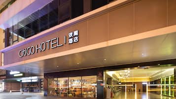 Un hotel con fachada moderna, amplios ventanales de vidrio y señalización destacada.