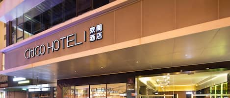 A hotel with a modern facade, large glass windows, and a prominent signage.