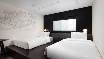 Habitación de hotel con dos camas, cabecera oscura, ventana grande y pared con un mapa.
