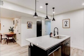 Enjoy cooking in this well-equipped kitchen with a central island, sink, and range hood.