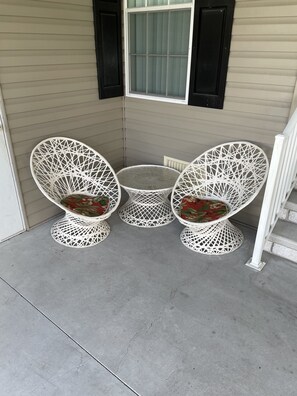 Relax in a serene outdoor seating area with intricately designed chairs and a round table.