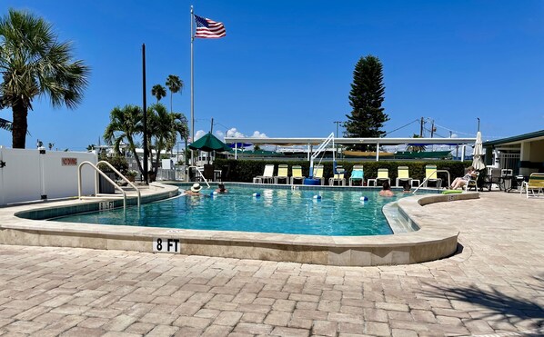 Relax by the pool surrounded by lounge chairs and umbrellas.