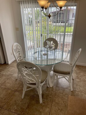Enjoy meals in this dining area with a round table and four comfortable chairs, surrounded by a beautiful garden view.
