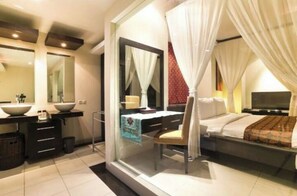 Relax in a serene space with a large bed, separate seating area, and spacious vanity.