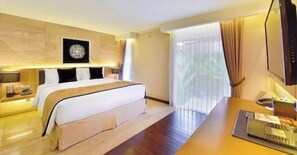Relax in comfort with a large bed and a desk area featuring a flat-screen TV and laptop.