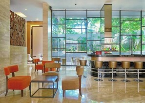 Relax in our spacious lobby with a seating area and bar, surrounded by lush greenery views.