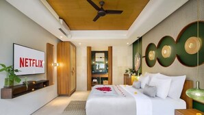 Ein modernes Schlafzimmer mit einem Bett, einem Fernseher und einem Deckenventilator.