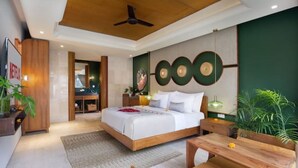 Ein modernes Hotelzimmer mit Holzboden, einem großen Bett, einem Schreibtisch und einer Wand in Grüntönen.