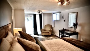 Une chambre avec un grand lit, une chaise, un bureau et une fenêtre.
