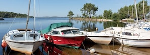 Boats docked in a serene marina, surrounded by calm water and a picturesque shoreline.