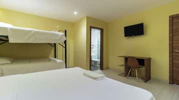 Una habitación de hotel con literas, un escritorio y un televisor.