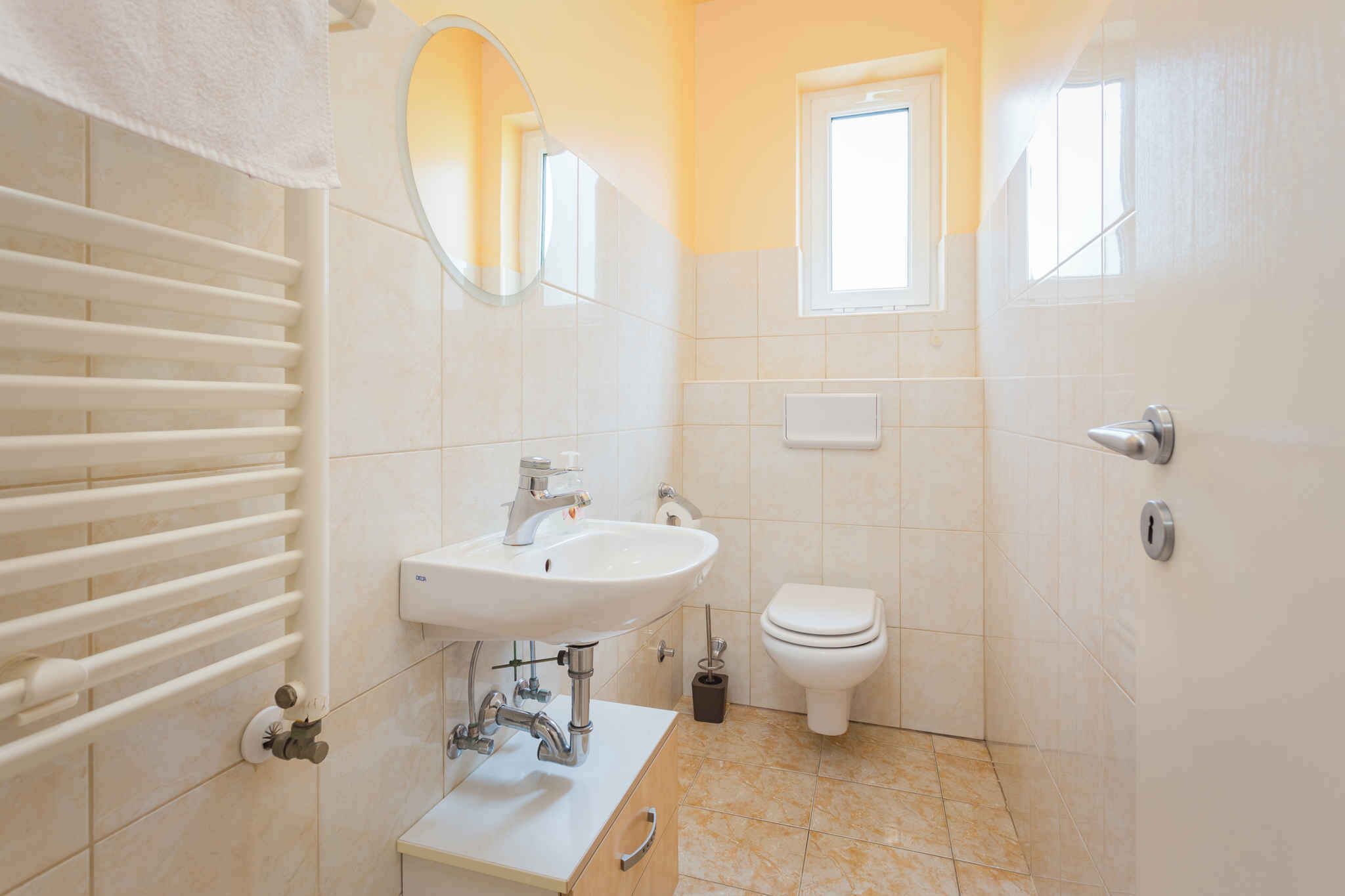 A bathroom with a white sink, toilet, and towel rack.