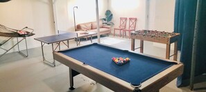 A pool table with a blue felt surface and a colorful ball rack in the center. - NEW! ARK Family Retreat w/ Game Room 3min to Ark! (Williamstown)