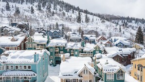 A snow-covered residential area with houses featuring traditional architecture and a mountainous backdrop. - Park City Motherlode F is in a Great Location with Year-Round Recreation! (Park City)