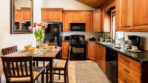 A kitchen with wooden cabinets, a black refrigerator, a stove, and a microwave. - Park City Motherlode F is in a Great Location with Year-Round Recreation! (Park City)