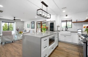 A modern kitchen with white cabinetry, a central island, and a built-in oven. - Casita in Paradise Valley Az Near Old Town Scottsdale- Tons of Privacy (Paradise Valley)