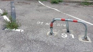 A parking area with marked spaces and a metal barrier. - Studio 2 Personnes Proche Plage et Commerces - 2phoe504 (CANET PLAGE)