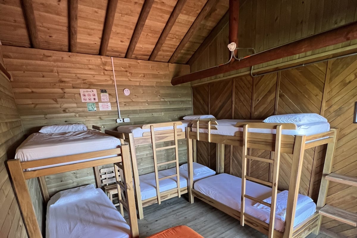 Une cabine équipée de quatre lits superposés et d’un lit simple avec un matelas orange.