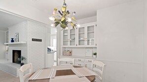 A dining area with a brick fireplace, white cabinets, and a chandelier. - Family Friendly, Updated, Charming Home in North Denton (Denton)