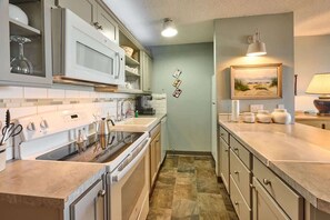 A kitchen with a stove, microwave, and cabinets. - Fun Ocean View Condo - Ground Floor - Fireplace! (Lincoln City)