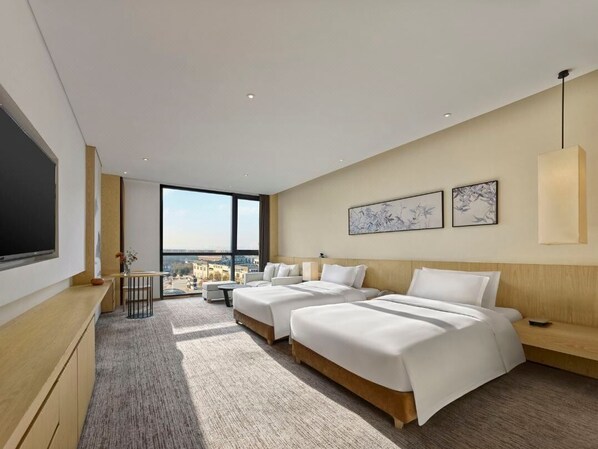 Une chambre d’hôtel moderne avec deux lits, une grande fenêtre et une vue sur la ville.