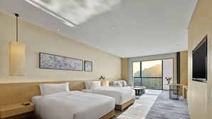 A hotel room with two beds, a TV, a desk, and a large window offering a city view. - Garrya Xian Lintong (Xi'an)
