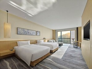 A hotel room with two beds, a TV, a desk, and a large window offering a city view. - Garrya Xian Lintong (Xi'an)