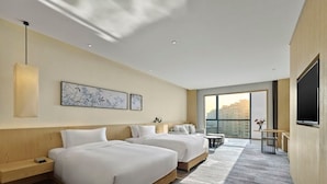 A hotel room with two beds, a TV, a desk, and a large window offering a city view. - Garrya Xian Lintong (Xi'an)