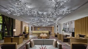 A modern hotel lobby with a central seating area, a reception desk, and a dining area. - Garrya Xian Lintong (Xi'an)