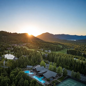 A lodge with a swimming pool, tennis court, and forested landscape. - Suncadia Lodge - Spa, Pool, Golf (Cle Elum)