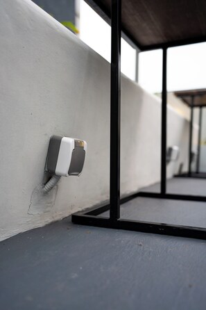 A white wall with a black metal frame and a white object attached to it. - Tuju Arteri Pods by Zuzu (Jakarta)