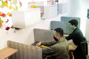 A modern office space with cubicles, a whiteboard, and a colorful geometric wall design. - Tuju Arteri Pods by Zuzu (Jakarta)
